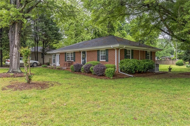ranch-style house featuring brick siding, fence, and a front lawn