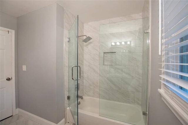 full bath with enclosed tub / shower combo, marble finish floor, and baseboards