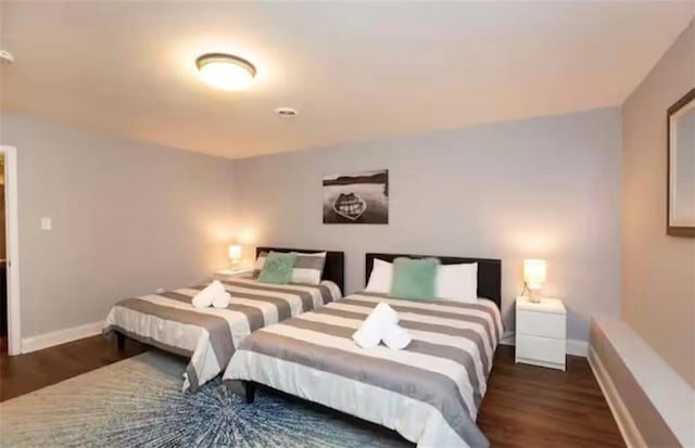 bedroom featuring baseboards and wood finished floors