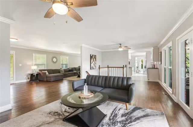 living room featuring baseboards, wood finished floors, a ceiling fan, and crown molding