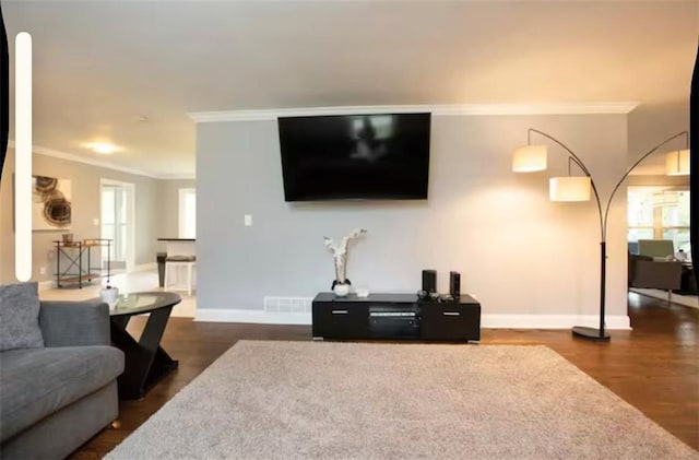 living room with visible vents, baseboards, dark wood-style flooring, and crown molding