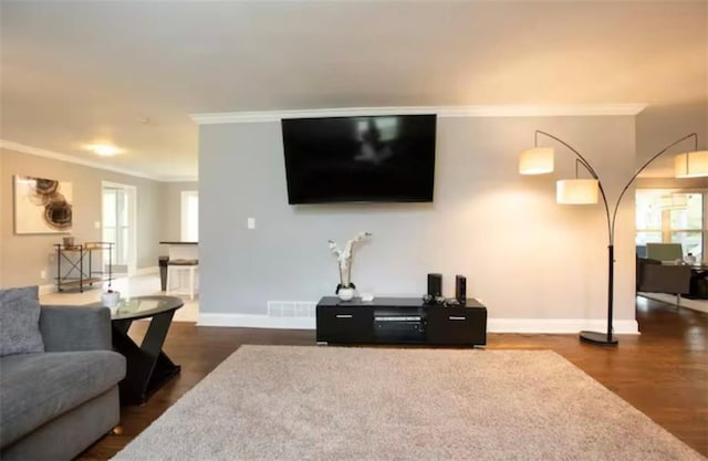 living area with baseboards, dark wood-style flooring, visible vents, and crown molding