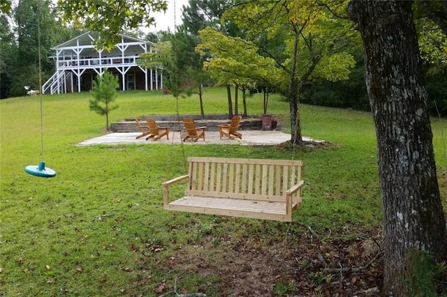 view of community featuring stairs, a yard, and a patio