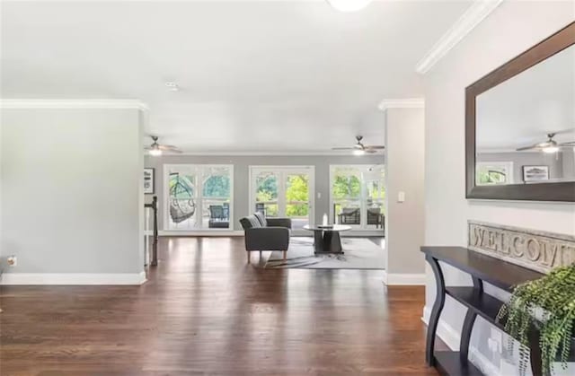 living area featuring ornamental molding, baseboards, and wood finished floors