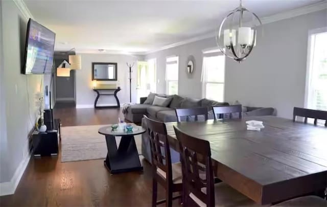 dining area featuring an inviting chandelier, baseboards, crown molding, and wood finished floors