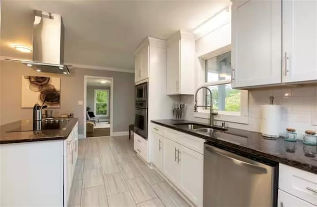 kitchen featuring a sink, white cabinetry, appliances with stainless steel finishes, decorative backsplash, and island exhaust hood