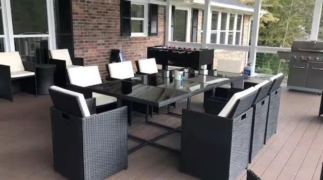 deck with outdoor dining space and area for grilling