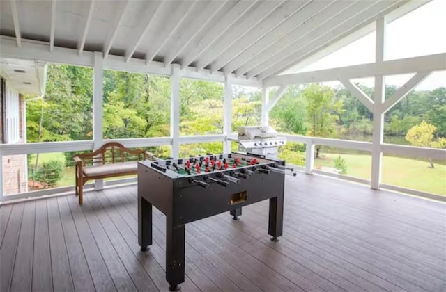 playroom with vaulted ceiling, plenty of natural light, and hardwood / wood-style flooring