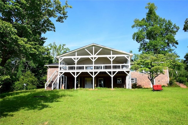 rear view of property with a yard, stairway, and a wooden deck