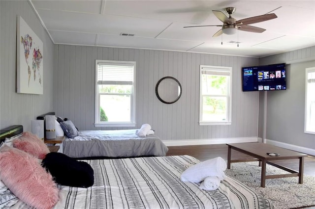 bedroom with wood finished floors, visible vents, and baseboards