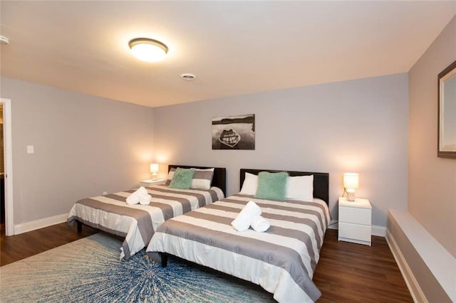 bedroom with visible vents, baseboards, and wood finished floors