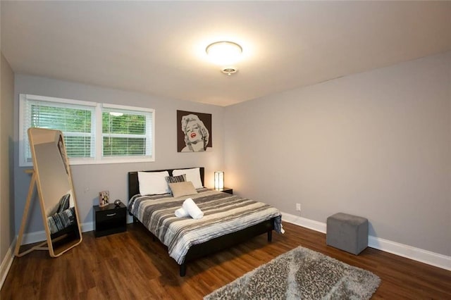 bedroom with baseboards and wood finished floors