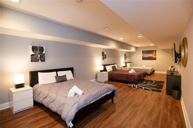 bedroom featuring baseboards, wood finished floors, and recessed lighting