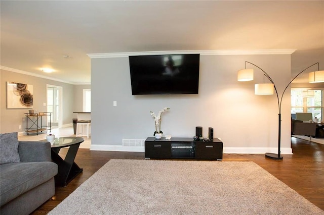 living area featuring dark wood-style floors, baseboards, visible vents, and ornamental molding