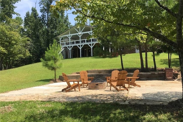 view of property's community with a yard, an outdoor fire pit, and a patio area