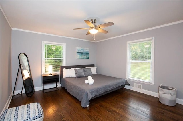 bedroom with crown molding, baseboards, and wood finished floors