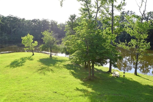 surrounding community with a water view and a yard