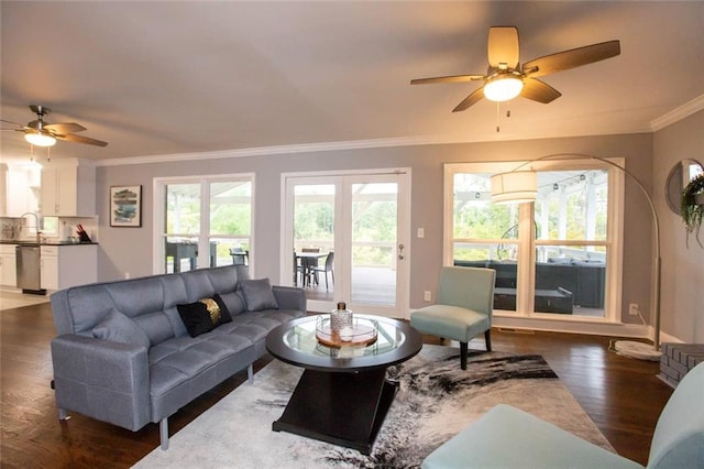 living area with ceiling fan, ornamental molding, dark wood finished floors, and a wealth of natural light