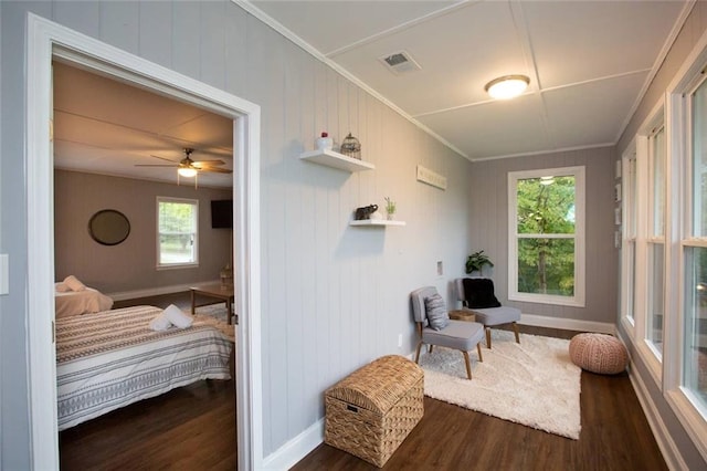 living area featuring dark wood-style flooring, visible vents, crown molding, and baseboards