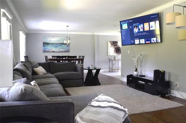 living area with a notable chandelier, baseboards, wood finished floors, and crown molding