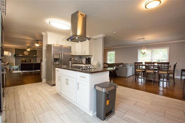 kitchen featuring island range hood, white cabinets, open floor plan, a brick fireplace, and stainless steel fridge with ice dispenser