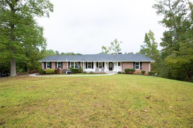 ranch-style house featuring a porch, a front yard, and brick siding