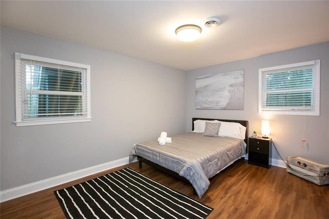 bedroom with baseboards and wood finished floors