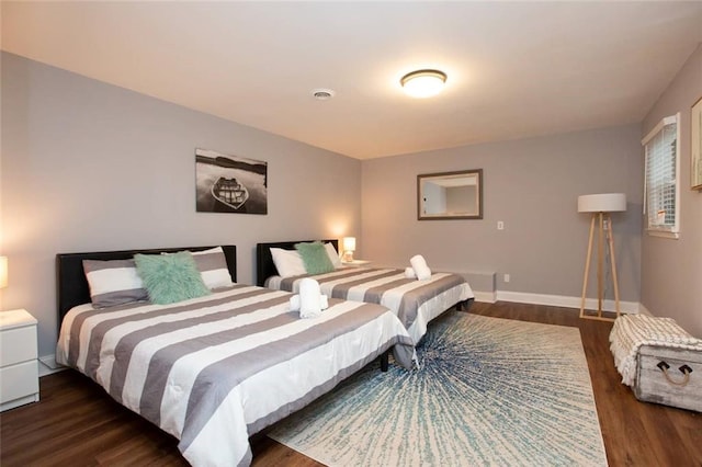 bedroom with dark wood-style flooring and baseboards