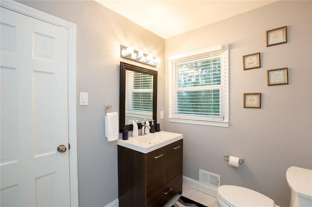 bathroom with toilet, baseboards, visible vents, and vanity