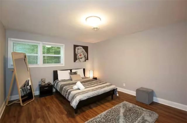 bedroom featuring wood finished floors and baseboards