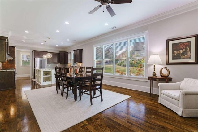 dining area with crown molding, dark wood-type flooring, and ceiling fan