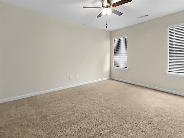 spare room with ceiling fan and carpet