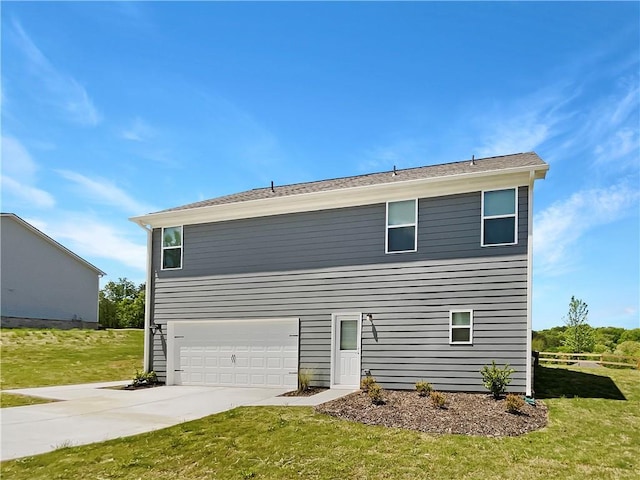 rear view of property with a garage and a yard