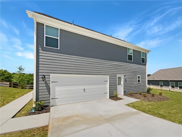 view of side of property featuring a garage and a yard