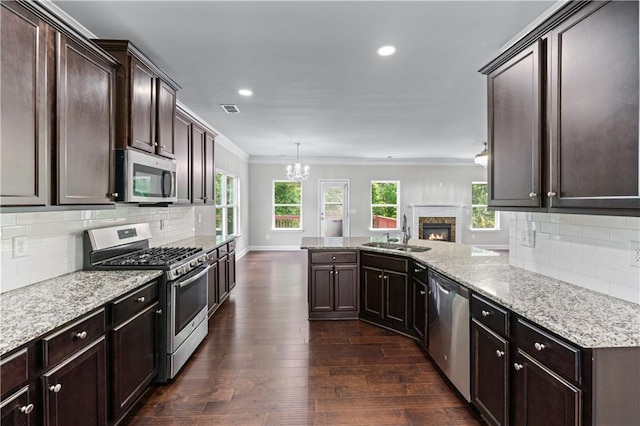 350 Paces Dr, Lithia Springs, GA 30122 - kitchen featuring appliances with stainless steel finishes, a sink, a chandelier, dark wood-type flooring, and dark brown cabinetry