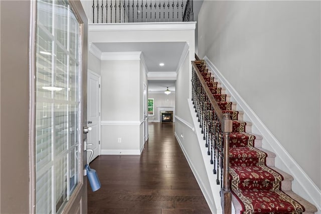 350 Paces Dr, Lithia Springs, GA 30122 - foyer featuring ornamental molding, stairs, a glass covered fireplace, dark wood finished floors, and baseboards