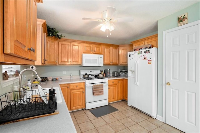 kitchen with white appliances, light tile patterned flooring, ceiling fan, and light countertops