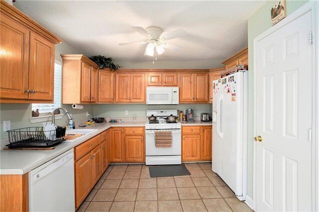 kitchen featuring white appliances, ceiling fan, a sink, and light countertops