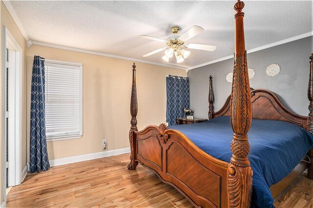 bedroom featuring baseboards, a textured ceiling, ornamental molding, and wood finished floors