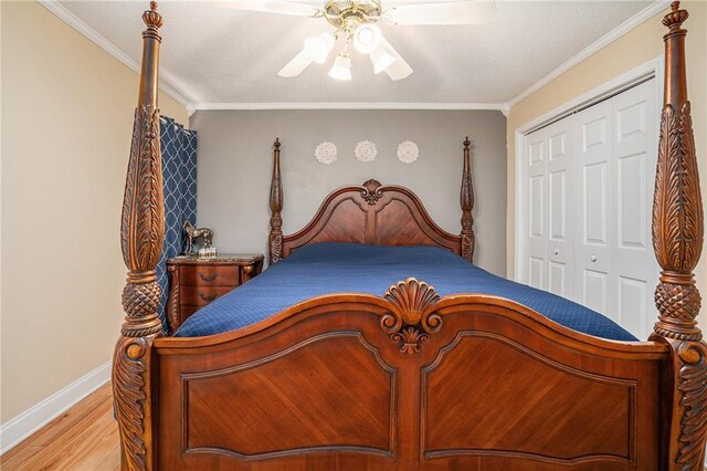 bedroom with a ceiling fan, crown molding, light wood-type flooring, baseboards, and a closet