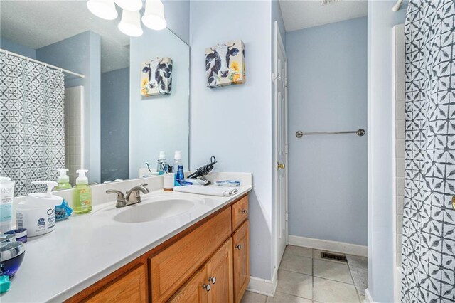 full bath with vanity, visible vents, baseboards, tile patterned floors, and a shower with curtain