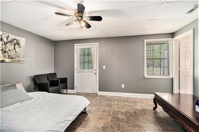 bedroom featuring a ceiling fan, baseboards, visible vents, and a paneled ceiling