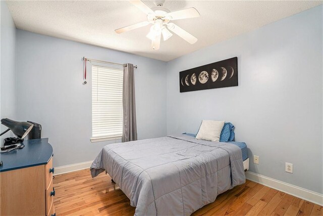 bedroom featuring a ceiling fan, baseboards, and light wood finished floors
