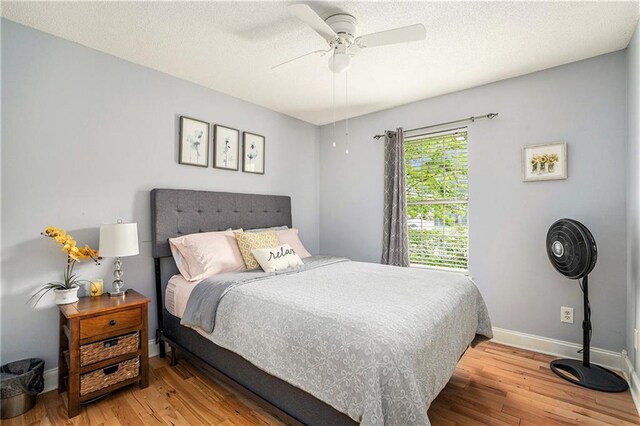 bedroom with baseboards, ceiling fan, and wood finished floors
