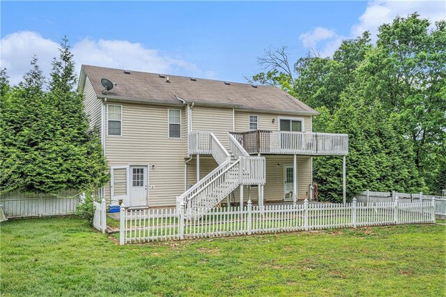rear view of property featuring a deck, a fenced backyard, a shingled roof, a lawn, and stairway