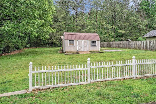 view of yard with fence, an outbuilding, and a shed