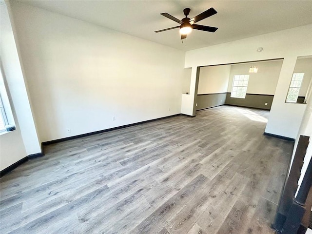 spare room featuring ceiling fan, wood finished floors, and baseboards