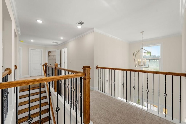 hallway featuring crown molding, a notable chandelier, and carpet flooring