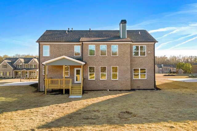 back of property featuring a garage and a yard