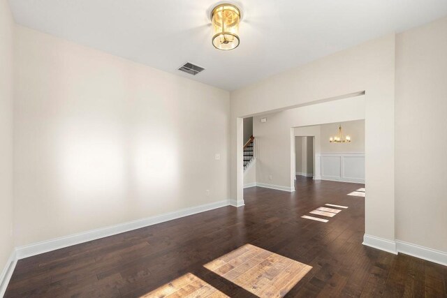 unfurnished room with an inviting chandelier and wood-type flooring